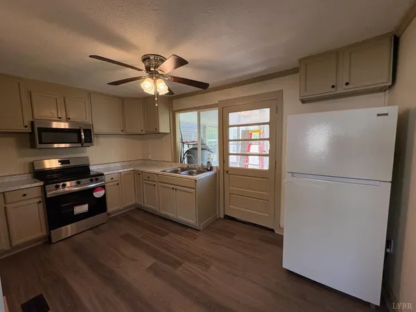 a kitchen with granite countertop a refrigerator oven a sink dishwasher and a stove with wooden floor