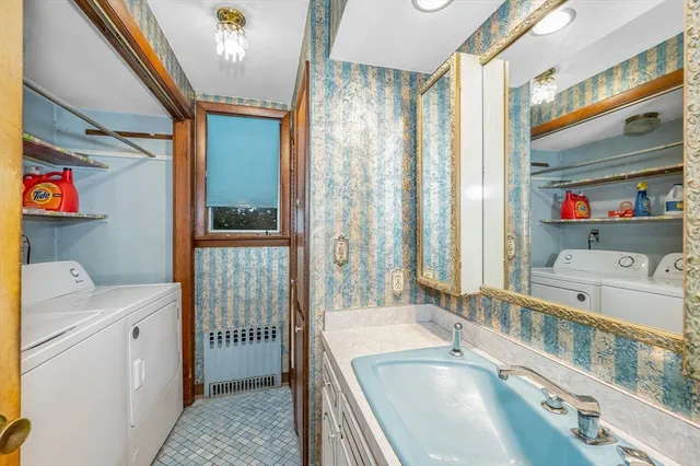 a bathroom with a tub a sink and a large mirror next to a window