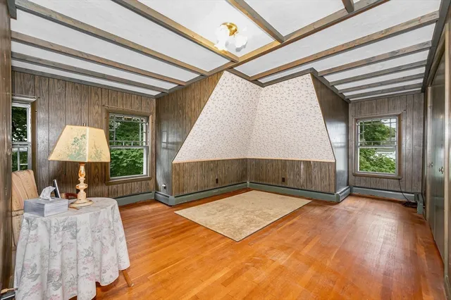 a view of a room with wooden floor and a potted plant
