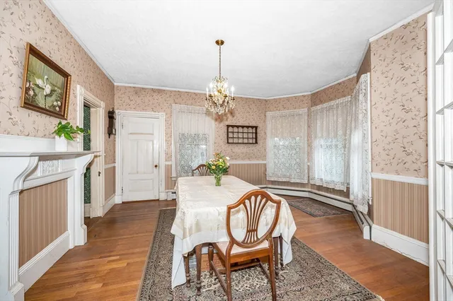 a dining room with furniture a chandelier and wooden floor