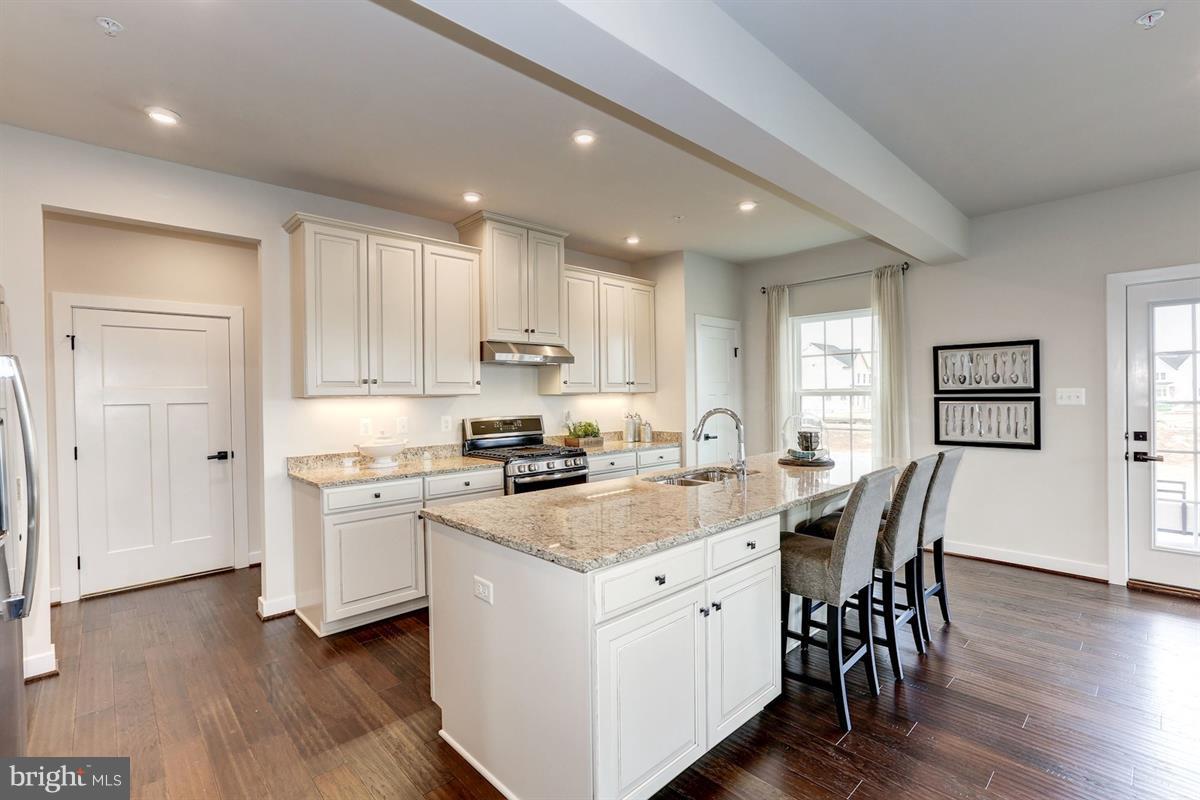 1258 Upper Patuxent Ridge Road Odenton, MD 21113 - Photo 6 of 23 a kitchen with stainless steel appliances granite countertop a white stove top oven a sink dishwasher and a refrigerator with wooden floor