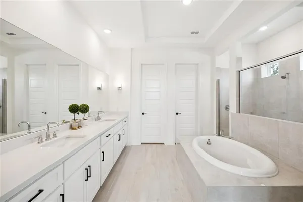 a spacious bathroom with a double vanity sink mirror double and bathtub