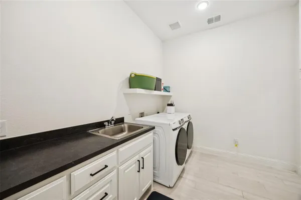 a utility room with sink dryer and washer