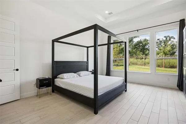 a bedroom with a bed and large window