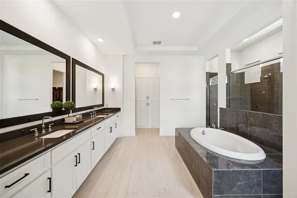 a large bathroom with a double vanity sink and mirror with shower