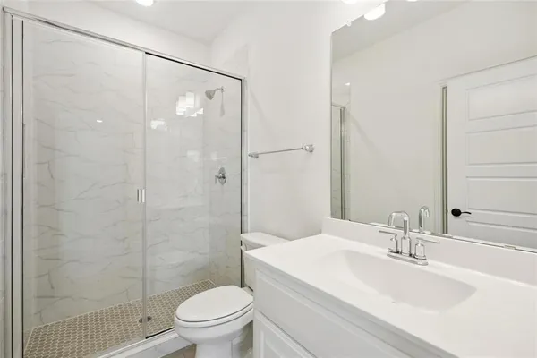 a bathroom with a sink a toilet and shower