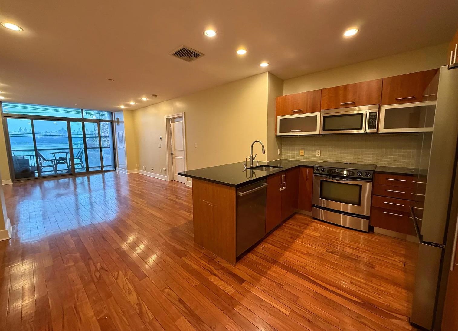 8125 River Road, Unit 3C North Bergen, NJ 07047 - Photo 4 of 23 a kitchen with stainless steel appliances granite countertop a sink and a stove top oven