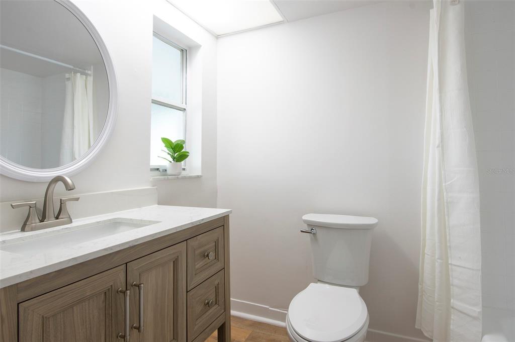 4725 Cove Circle, Unit 207 St. Petersburg, FL 33708 - Photo 11 of 46 a bathroom with a toilet sink and mirror