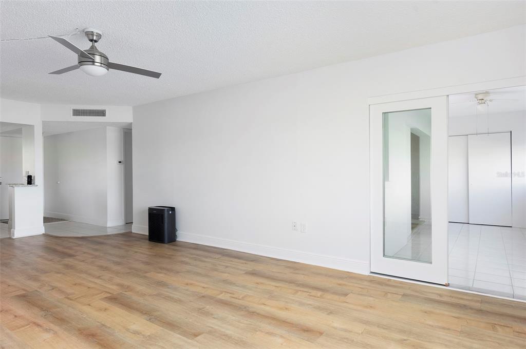 4725 Cove Circle, Unit 207 St. Petersburg, FL 33708 - Photo 3 of 46 a view of an empty room with wooden floor and a ceiling fan