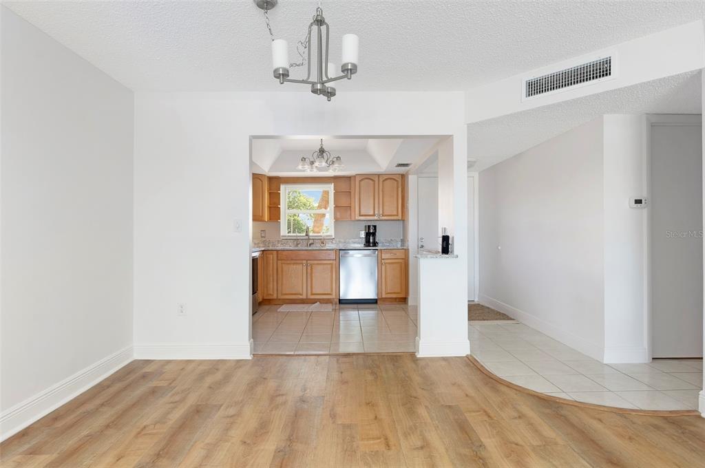 4725 Cove Circle, Unit 207 St. Petersburg, FL 33708 - Photo 4 of 46 a view of a kitchen with furniture and wooden floor