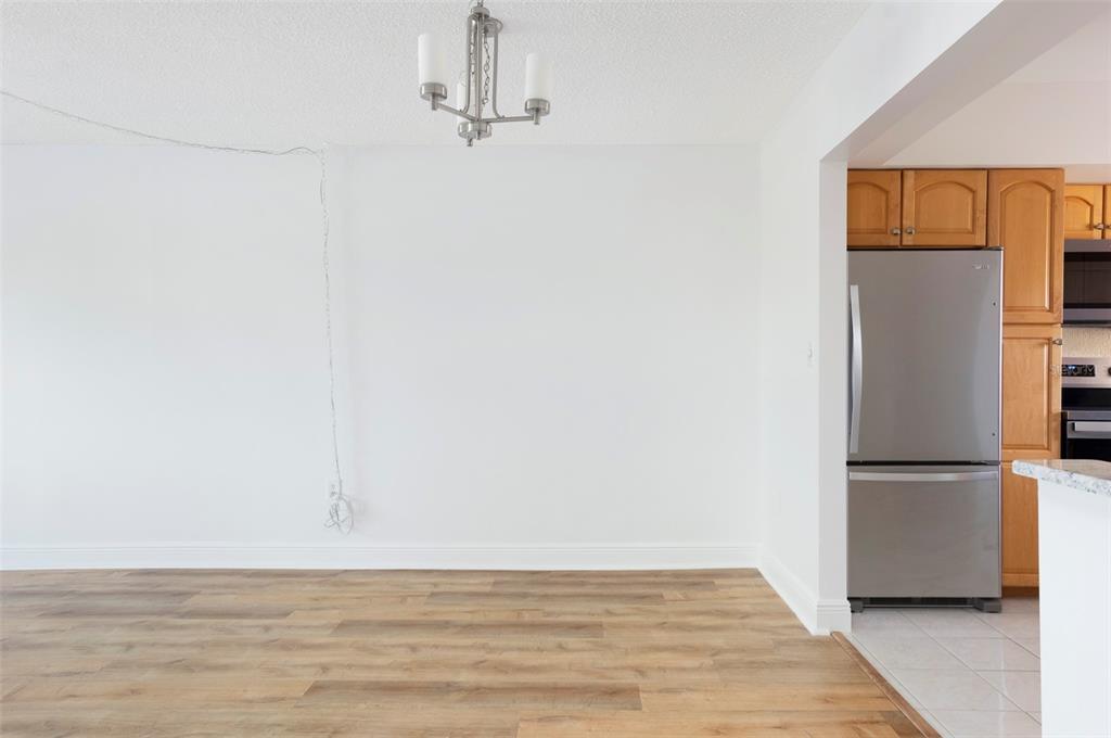 4725 Cove Circle, Unit 207 St. Petersburg, FL 33708 - Photo 7 of 46 a view of empty room with wooden floor and window