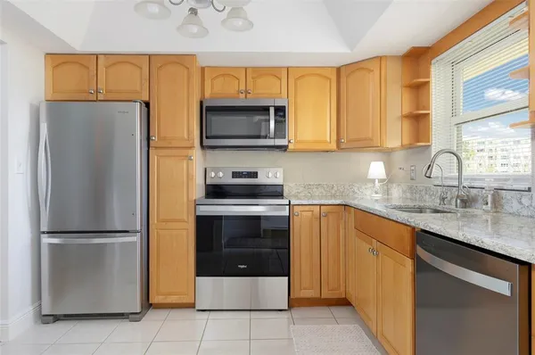 a kitchen with stainless steel appliances granite countertop a refrigerator sink and microwave