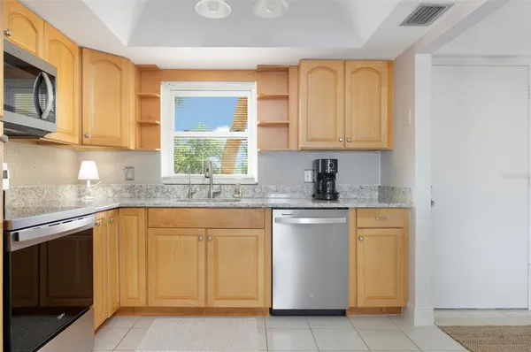a kitchen with stainless steel appliances granite countertop a sink stove and microwave