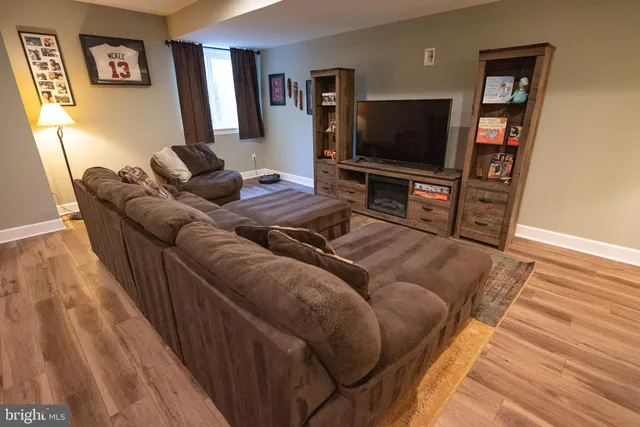 a living room with furniture a flat screen tv and kitchen view