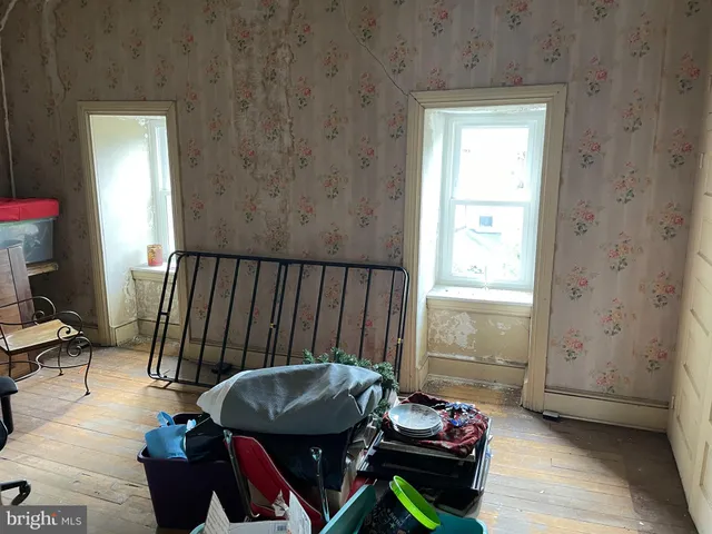 an empty room with wooden floor and window