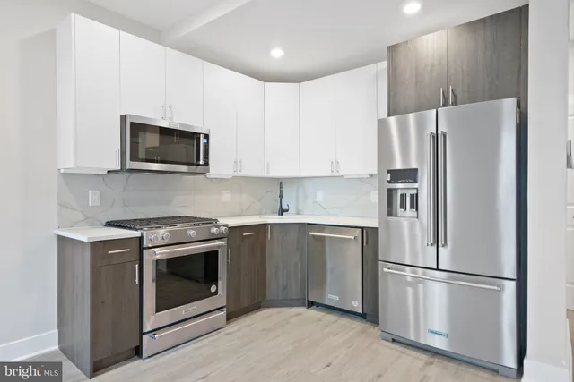 a kitchen with stainless steel appliances granite countertop a refrigerator stove a sink and a microwave