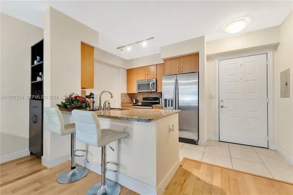 a kitchen with stainless steel appliances granite countertop a refrigerator and a stove top oven
