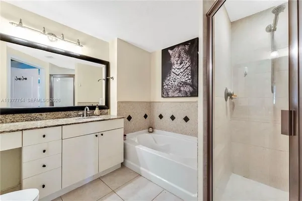 a bathroom with a bathtub a double vanity sink and mirror