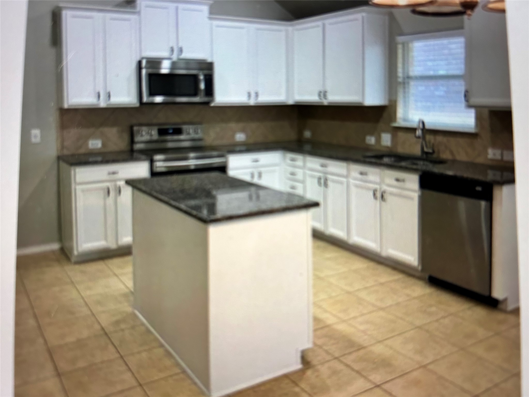 211 Animas Drive Georgetown, TX 78626 - Photo 6 of 25 a kitchen with stainless steel appliances granite countertop a sink a stove a microwave and cabinets