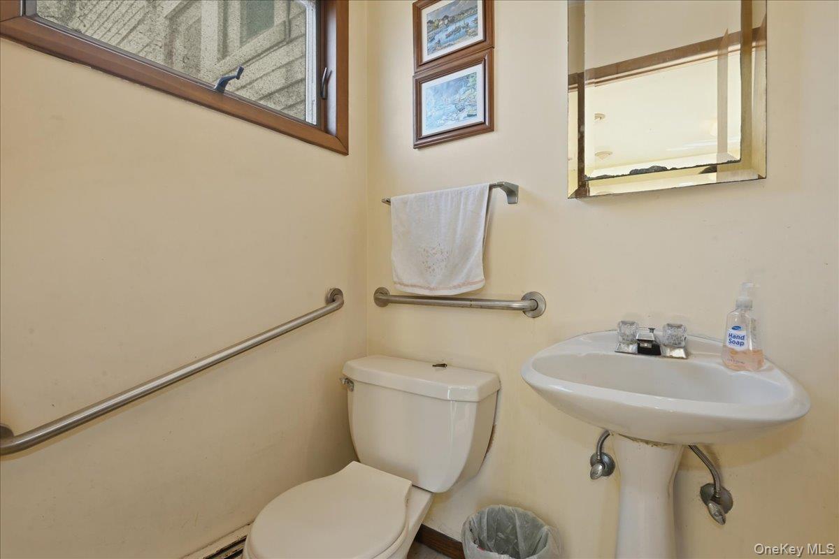 590 Waterview Road Oceanside, NY 11572 - Photo 11 of 26 a bathroom with a toilet sink and mirror