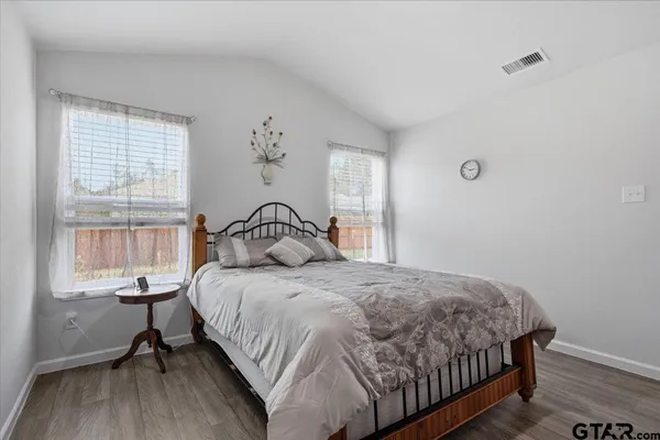 a bedroom with a bed a table and windows