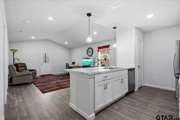 a open kitchen with stainless steel appliances granite countertop a sink stove and wooden floor