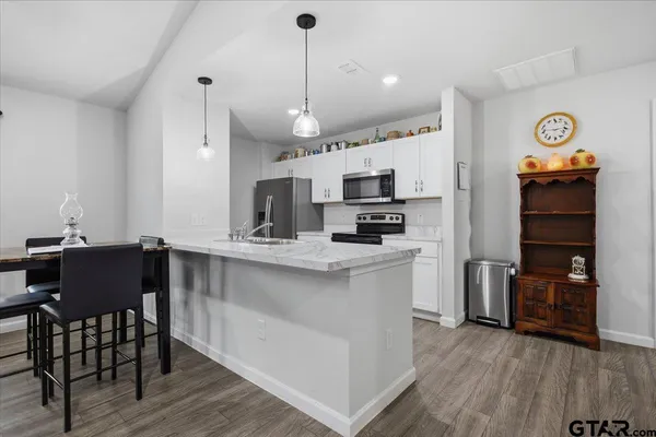 a kitchen with stainless steel appliances a stove a sink and a refrigerator