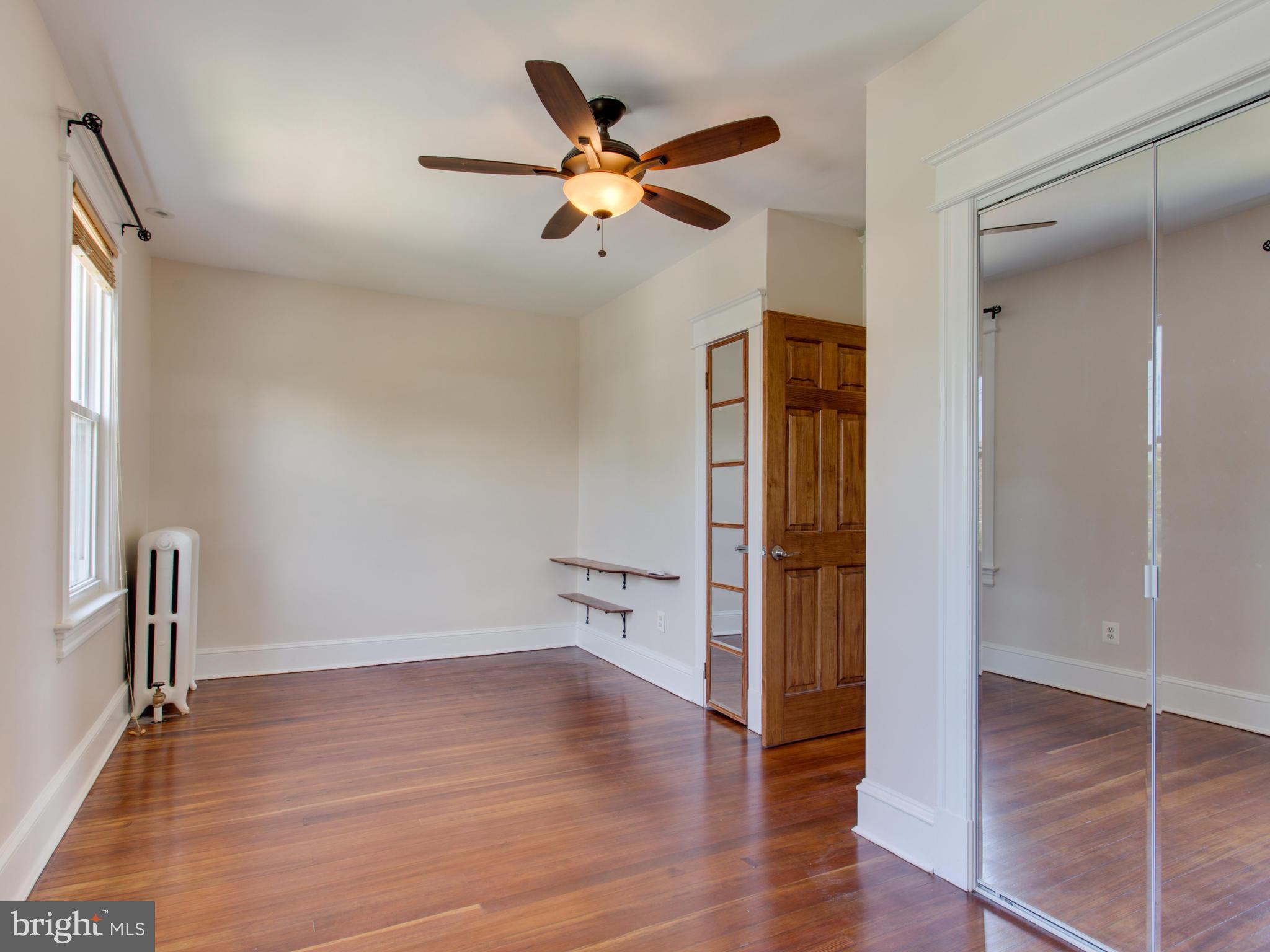 408 Rittenhouse Street Northwest Washington, DC 20011 - Photo 13 of 30 an empty room with wooden floor and a ceiling fan