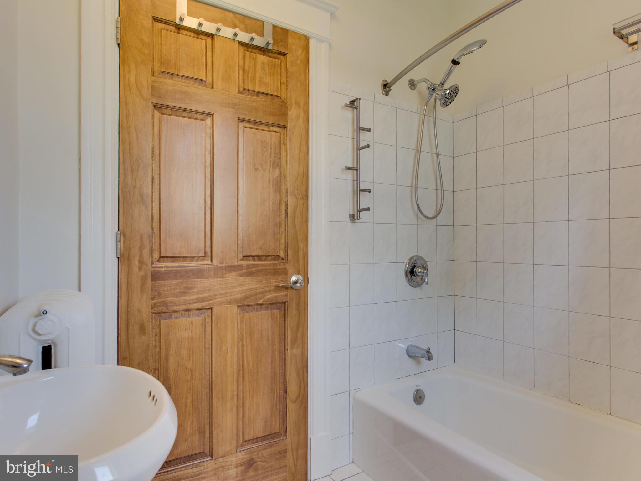 408 Rittenhouse Street Northwest Washington, DC 20011 - Photo 17 of 30 a bathroom with a tub a sink and glass door