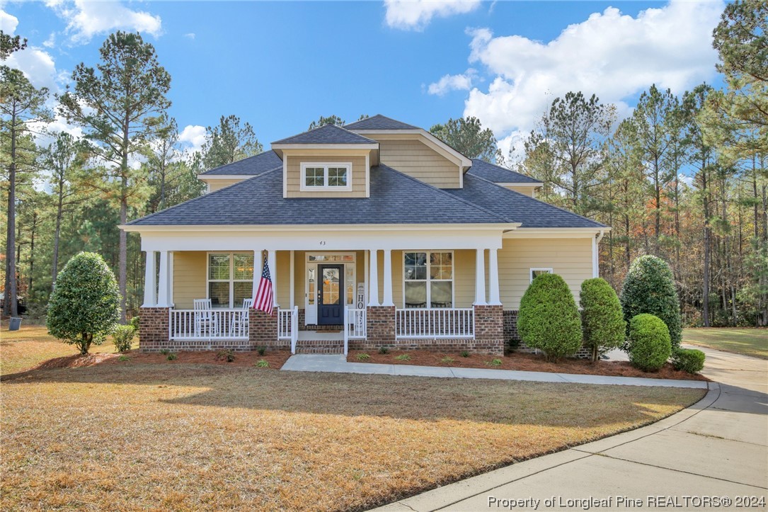 a front view of a house with a yard and potted plants