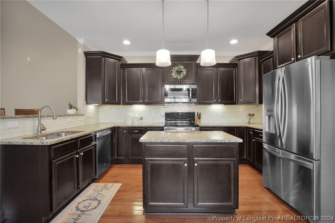 43 Shellnut Circle Spring Lake, NC 28390 - Photo 12 of 35 a kitchen with kitchen island a sink stainless steel appliances and cabinets