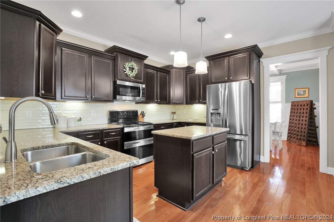 43 Shellnut Circle Spring Lake, NC 28390 - Photo 13 of 35 a kitchen with stainless steel appliances granite countertop a refrigerator a sink a stove and oven with wooden floor