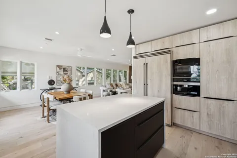 a kitchen with stainless steel appliances a sink a stove a refrigerator and cabinets
