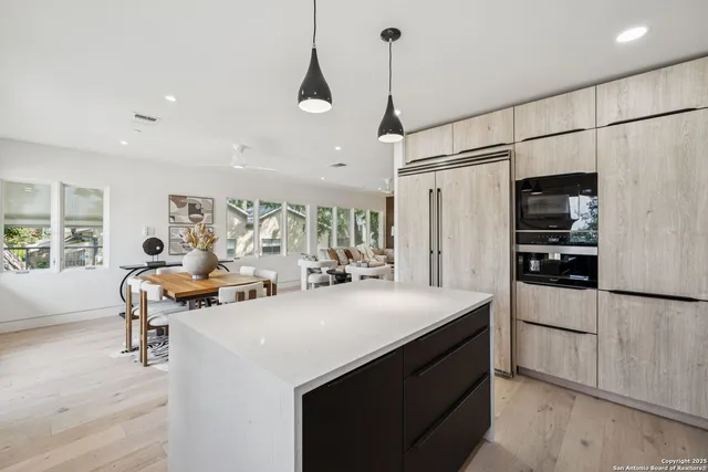 a kitchen with stainless steel appliances a sink a stove a refrigerator and cabinets