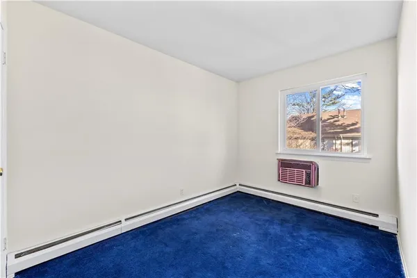 an empty room with wooden floor and window