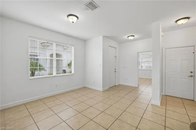 a view of an empty room with window and cabinet