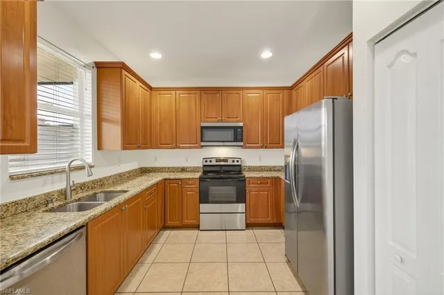a kitchen with stainless steel appliances granite countertop a refrigerator and a sink