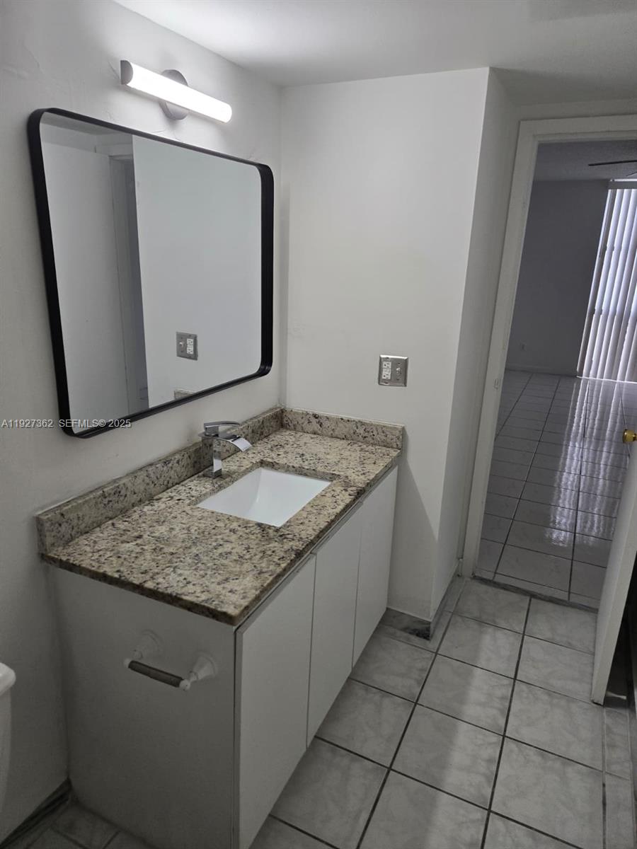 13499 Biscayne Boulevard, Unit 1204 North Miami, FL 33181 - Photo 6 of 13 a bathroom with a granite countertop sink and a mirror
