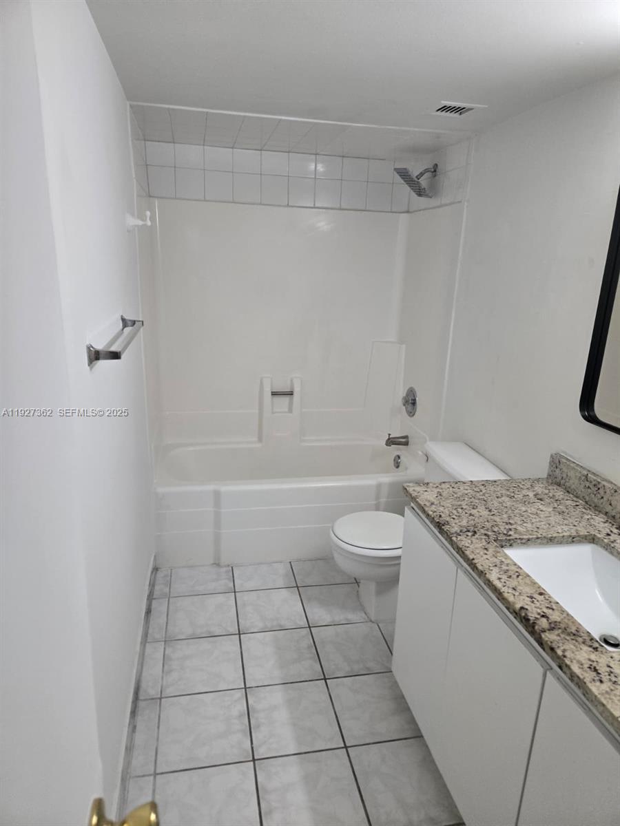 13499 Biscayne Boulevard, Unit 1204 North Miami, FL 33181 - Photo 7 of 13 a bathroom with a granite countertop sink a toilet and shower