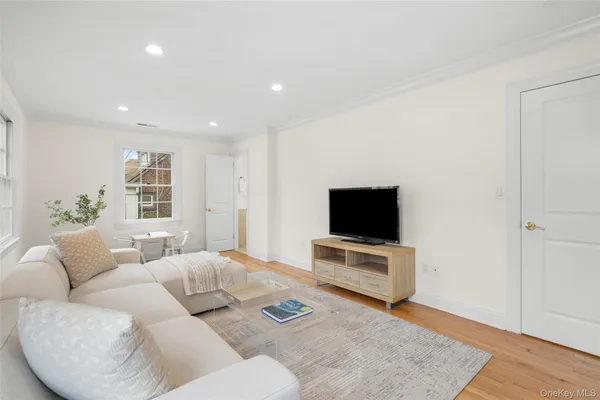 a living room with furniture a flat screen tv and a large window