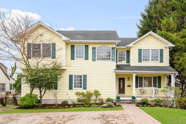 a front view of a house with a yard and potted plants