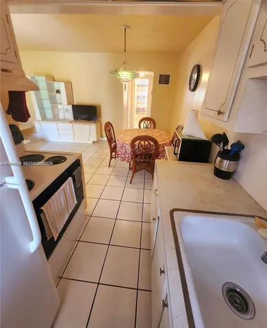 a kitchen with a sink a stove and cabinets