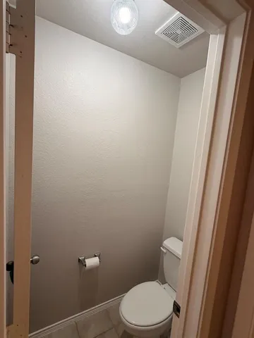 a white toilet sitting next to a shower