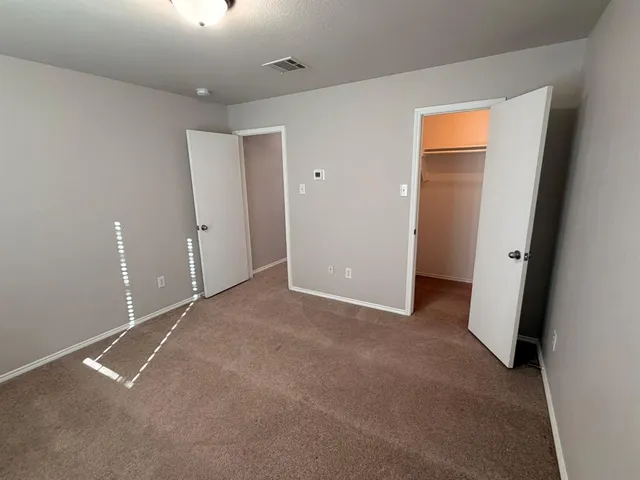 an empty room with closet and windows