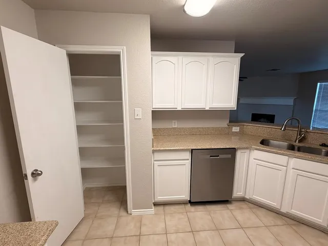 a kitchen with a sink window and cabinets
