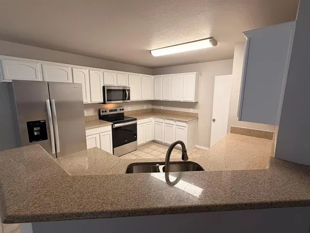 a kitchen with a refrigerator a stove a microwave and cabinets