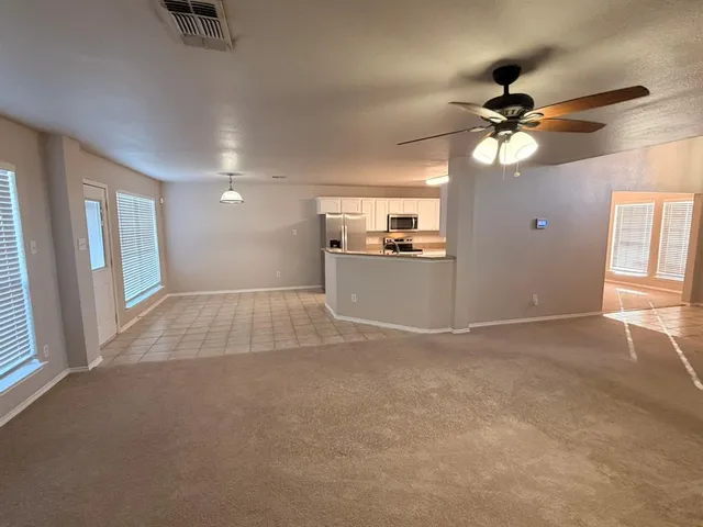 a view of a kitchen with a stove cabinets a ceiling fan and wooden floor