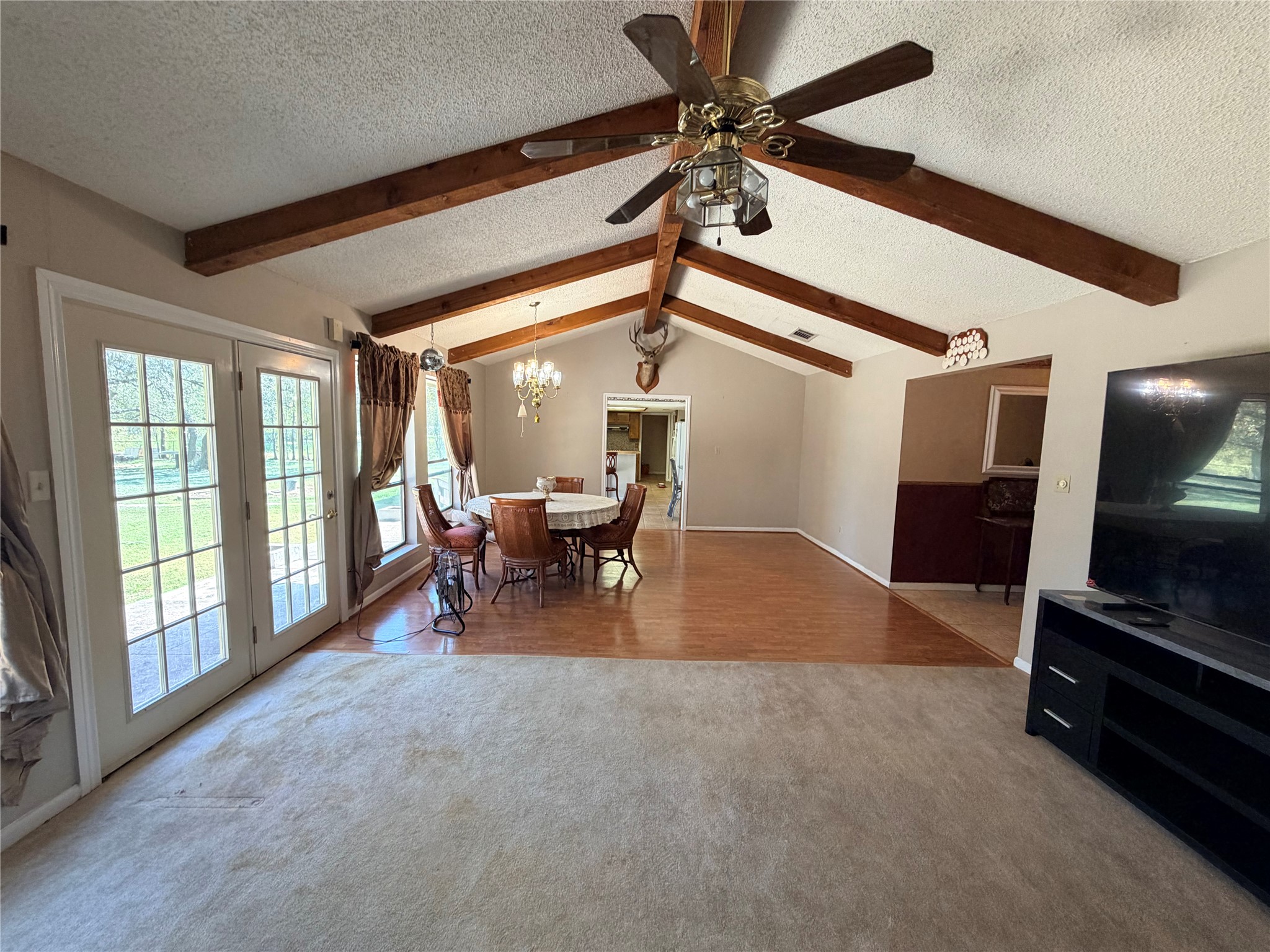 2800 Robin Road Manchaca, TX 78652 - Photo 8 of 28 Exposed wood beams accent the vaulted ceiling of this open living and dining layout.