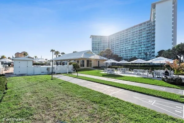 a front view of a house with a garden and trees