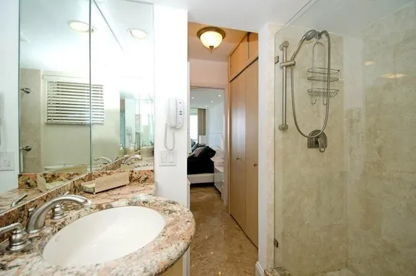 a en suite bathroom with a granite countertop sink and a mirror